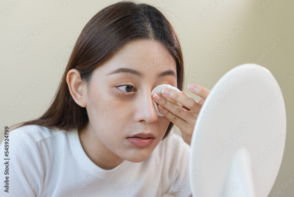 Woman using cotton pad wipe to clean cosmetic on her face Woman using cotton pad wipe to clean cosmetic on her face