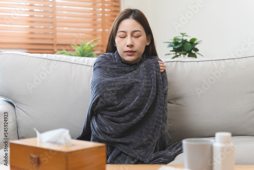Foto Young woman covering her body by blanket have shivering from cold weather in win