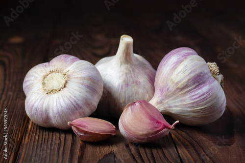 Garlic cloves on wooden table. Fresh peeled garlics and bulbs.