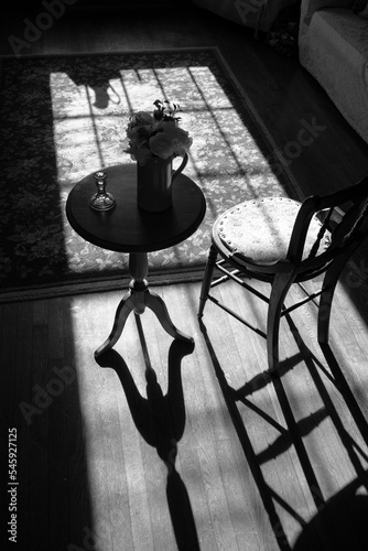 Strong Shadows Cast from a Chair and Small Table as Sunlight Comes Through a Window