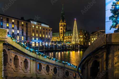 Town hall of Hamburg during christmas time with christmas tree and christmas lights in foreground
