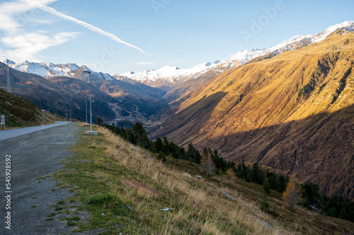 Alpine valley between hills with asphalt road.