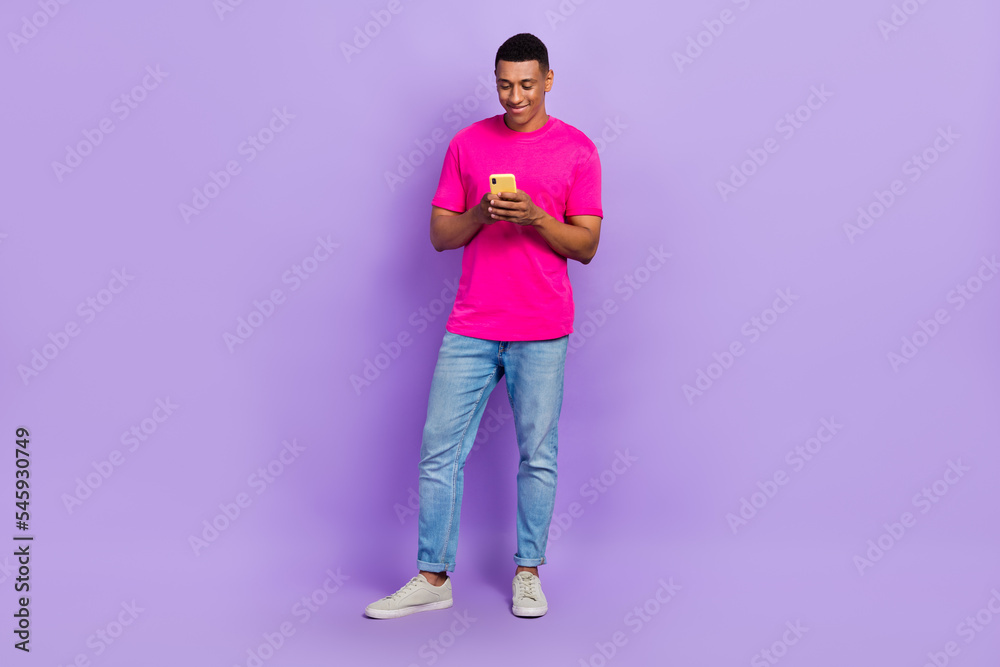 Full length photo of cheerful stylish man blogger use modern device typing texting write post repost isolated on purple color background Full length photo of cheerful stylish man blogger use modern device typing texting write post repost isolated on purple color background