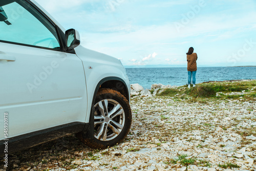 woman standing at edge seaside looking at sea car travel concept © phpetrunina14