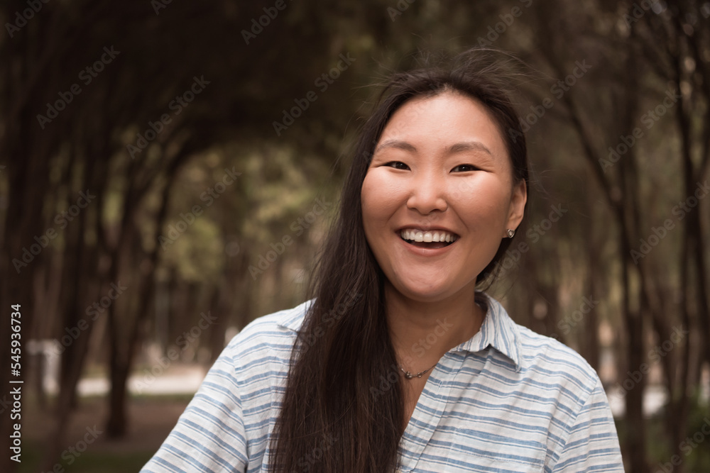 Young happy laughing asian woman walking in city park at summer Young happy laughing asian woman walking in city park at summer
