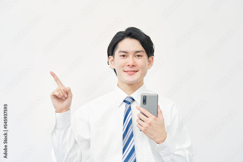 スマホを持って左を指差すビジネスマン 白背景 スマホを持って左を指差すビジネスマン 白背景