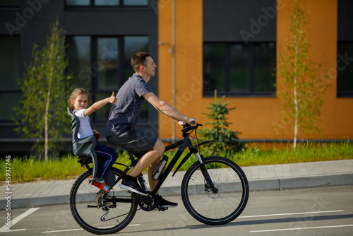father riding bike with son in bike seat