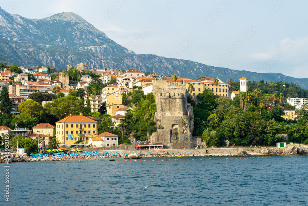View of city Herceg Novi and fortress from sea. City beach. Adriatic Sea. Coastal town in Montenegro located at entrance to Bay of Kotor and at foot of Mount Orjen