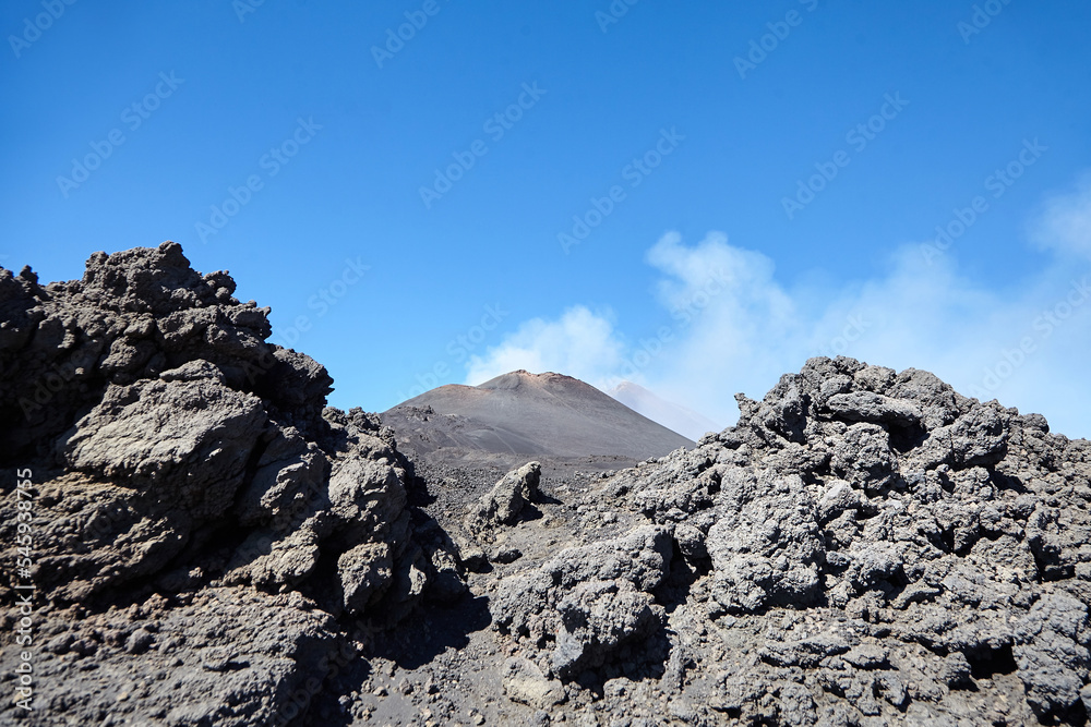 Mount Etna, Sicily, Italy. Black lava stones. Landscape with crater of Mount Etna. Smoking peak of active volcano Etna. Mount Etna, Sicily, Italy. Black lava stones. Landscape with crater of Mount Etna. Smoking peak of active volcano Etna.