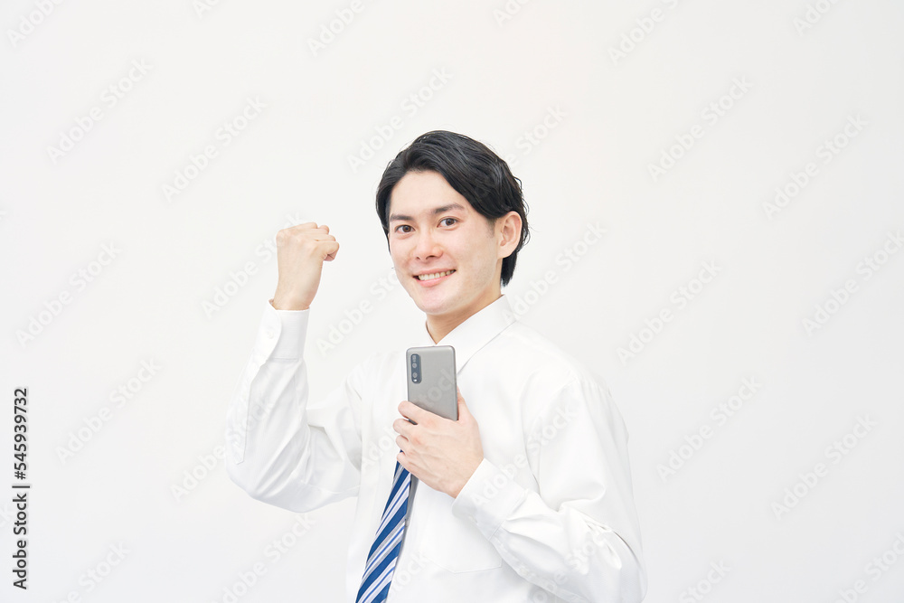 スマホを持ってガッツポーズするビジネスマン 白背景 スマホを持ってガッツポーズするビジネスマン 白背景