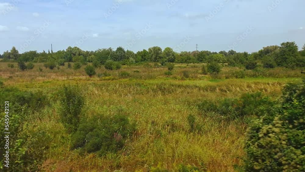 Travel by train. View from train window on beautiful landscape with hills and forest in daytime. View from window of car, bus, train. Traveling from train on sunny day Travel by train. View from train window on beautiful landscape with hills and forest in daytime. View from window of car, bus, train. Traveling from train on sunny day