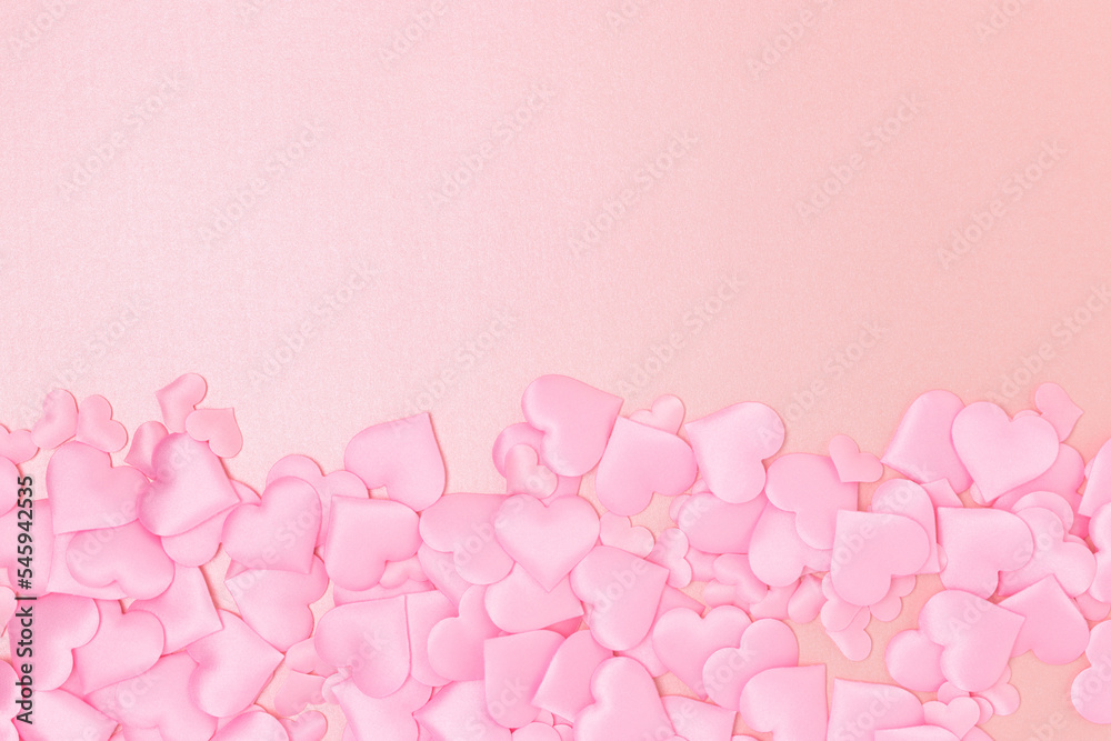 Textile hearts confetti on a pink glittering background. Copy space. Monochrome concept.