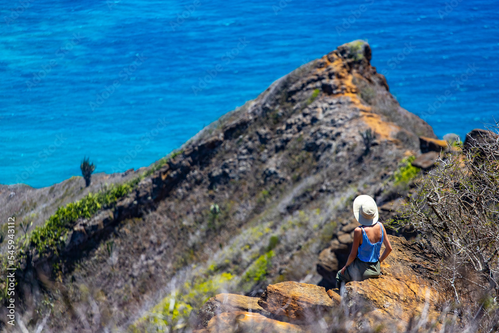 Obraz premium girl in a hat enjoys the oahu panorama from the top of the famous koko crater railway trailhead, oahu, hawaii, hiking in hawaii, holiday in hawaii
