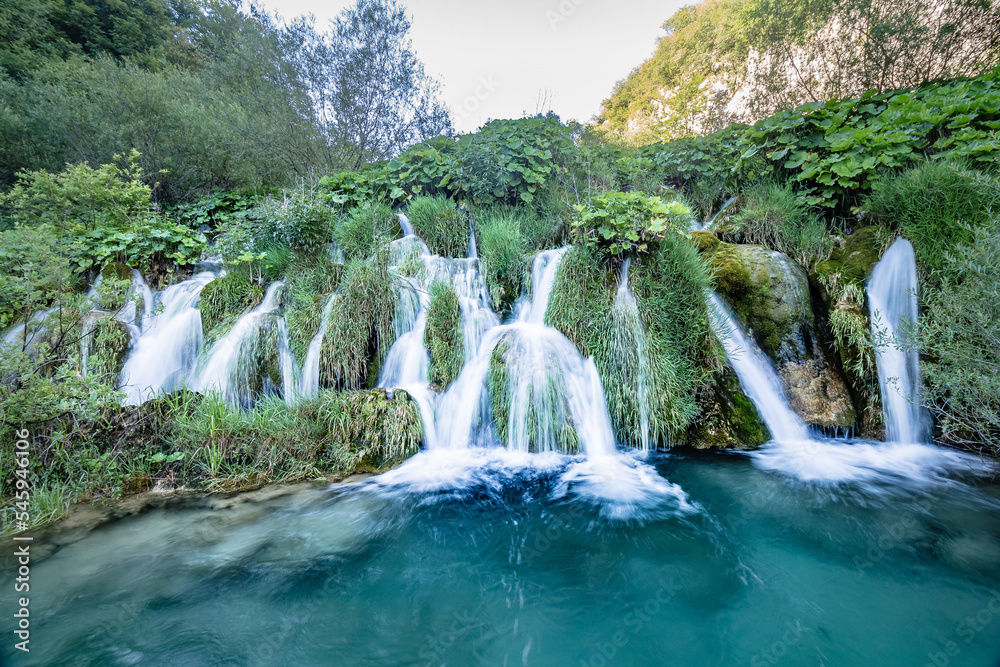 Naklejka premium Majestic view of waterfall with crystal clear water in forest in The Plitvice Lakes National Park in Croatia Europe.