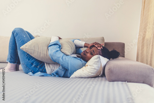 Cropped shot of an attractive young woman lying down on her bed and suffering from period pains at home. Healthcare and Medicine.