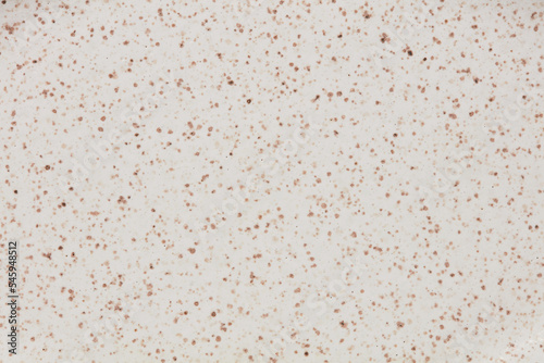 Beige and white ceramic texture of plate with brown dots. Close up