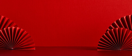 Chinese New Year celebration concept. Banner design with red paper fans decorations on red background with copy space.