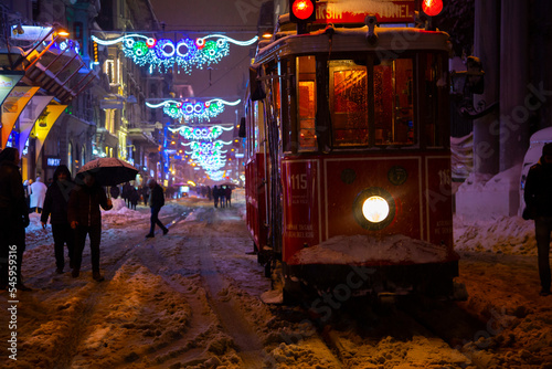 Snowy day in Taksim, Beyoglu. Nostalgic tram in Istiklal Street. Taksim Istiklal Street is a popular destination in Istanbul, Turkey. photo