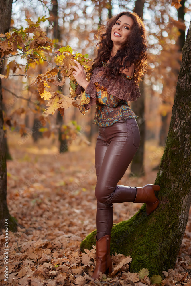 Portrait of a beautiful woman in the forest on a sunny autumn day
