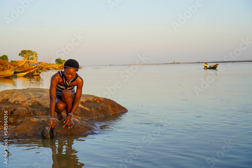 Fototapeta Beautiful African woman fetching water from the River