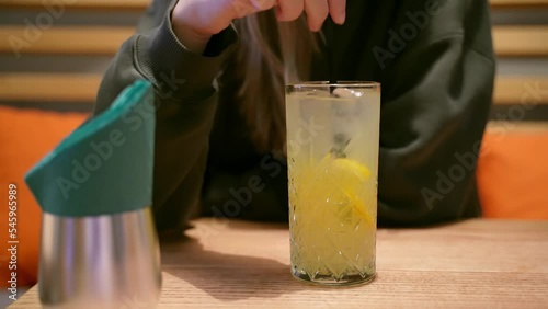 Young woman drinking lemonade with a cocktails tube in the restaurant