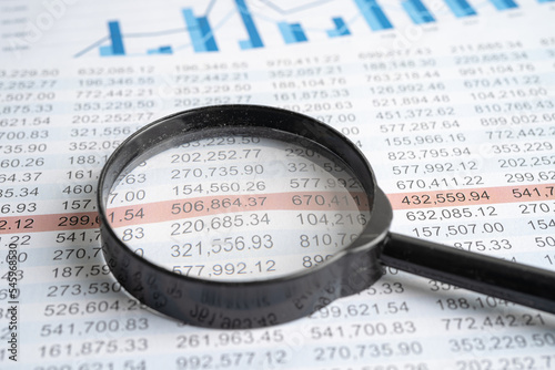 Magnifying glass on charts graphs spreadsheet paper. Financial development  Banking Account  Statistics  Investment Analytic research data economy.