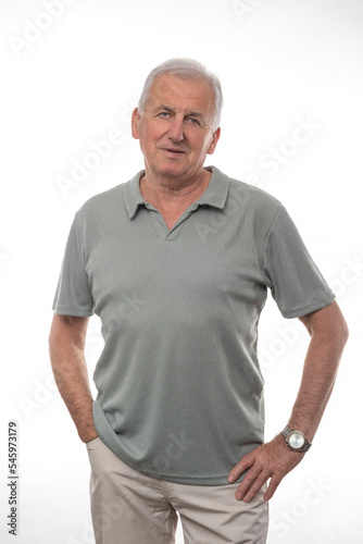 Positive older man in green polo looking at camera on isolated white background.