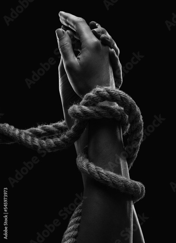 Foto Hands of a man with hands tied with ropes. Photo black and white