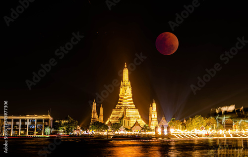 BANGKOK, THAILAND - November 8, 2022 : Lunar Eclipse,  Super Red Full Moon taken from top side of “Wat Arun Temple”,  This is a wonderful natural phenomenon with the view along Chao Praya River. © Bobbyphotos