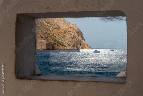 Reflet de bateau sur vitre avec vue sur la mer au port de Sifnos - Cyclades