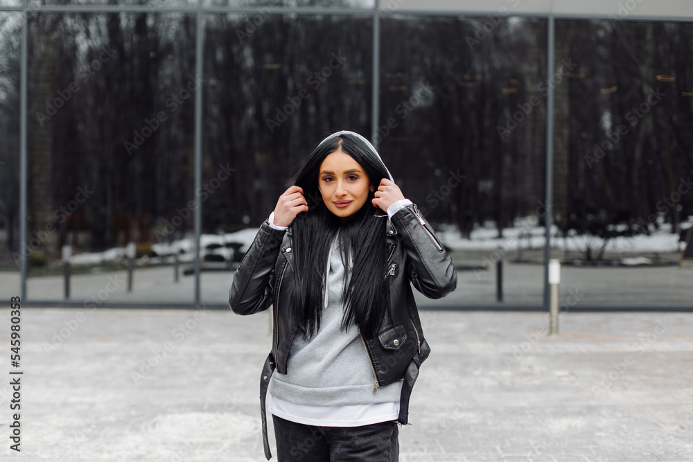 Fototapeta premium Young caucasian girl with dark long hair in sporty gray hoodie