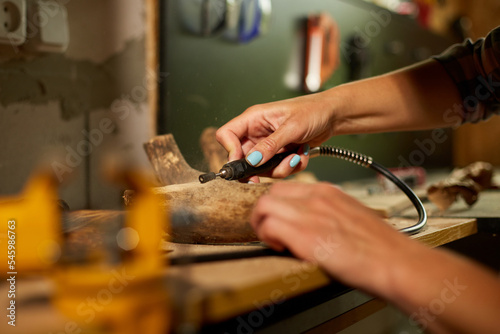 Slika na platnu Female using power wood working tools graver, carving while crafting