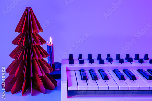Christmas background with midi keyboard and holiday decor with neon lights.