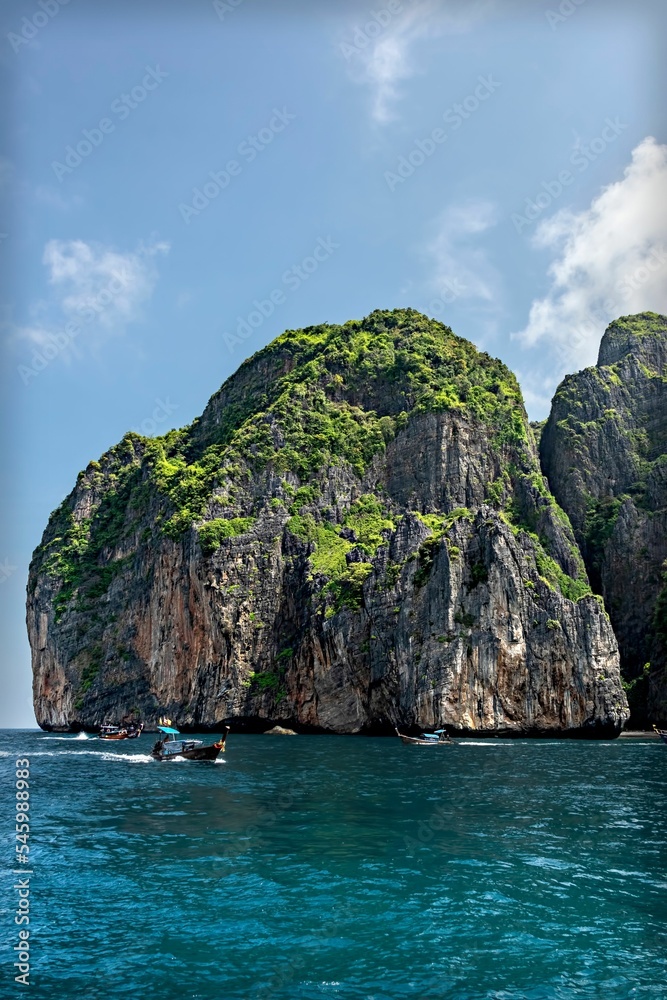 Obraz premium Aerial view of rock formations surrounded by water under blue bright sky