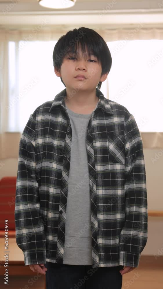 Vertical : A asian boy standing with strong will.