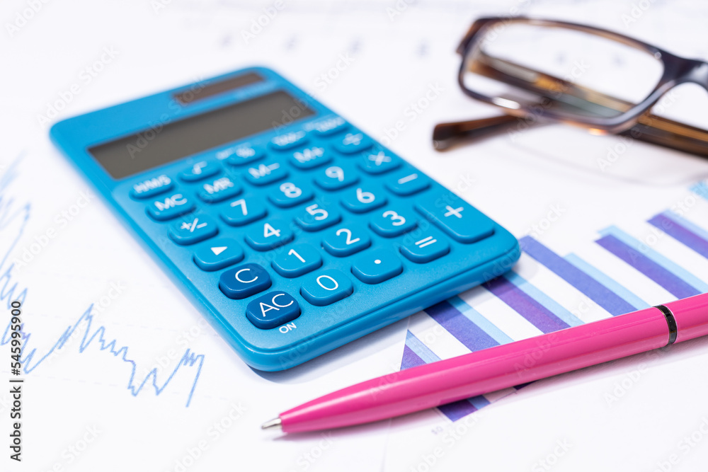 Business financial report background. Calculator, pen, eyeglasses and charts on work desk Business financial report background. Calculator, pen, eyeglasses and charts on work desk