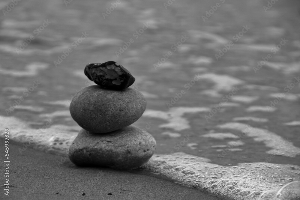 Grayscale shot of zen stones on the beach