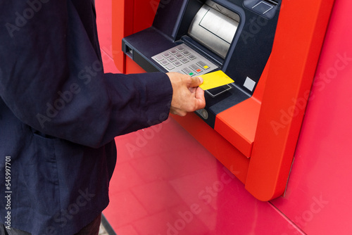 Crop man using ATM on street photo