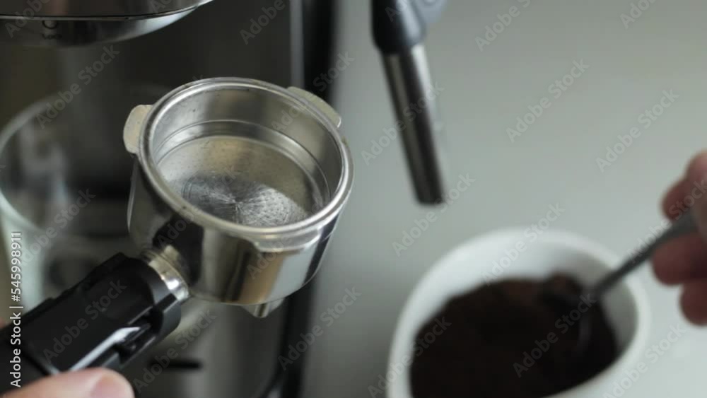 Putting ground coffee in the espresso machine Putting ground coffee in the espresso machine