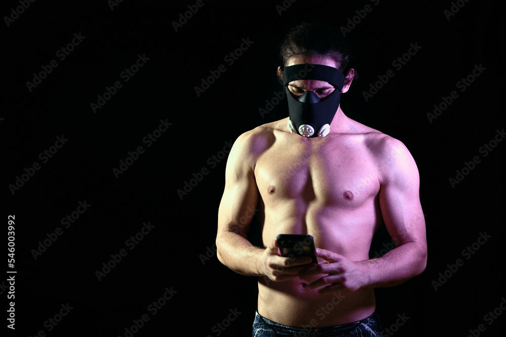 Fit young man training at home because of the international pandemic situation using a training app