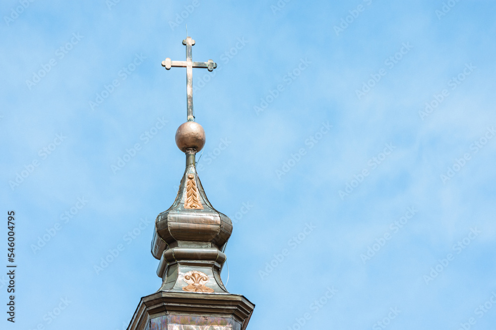 Catholic church tower with cross on top. Close up to a worship house tower