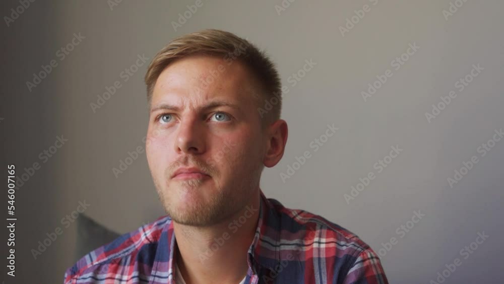 man eats popcorn and watches tv. frowns and concentrates man eats popcorn and watches tv. frowns and concentrates
