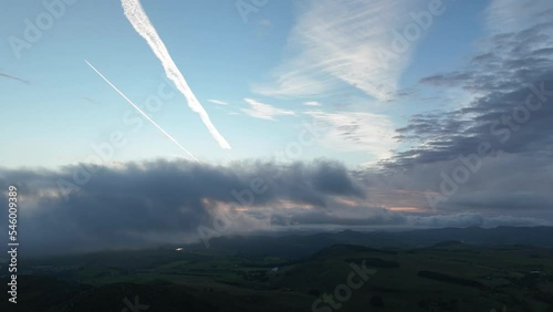 Time-lapse of moving clouds over rural area during sunset photo