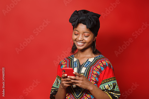Young African-American girl smiles while typing on her phone