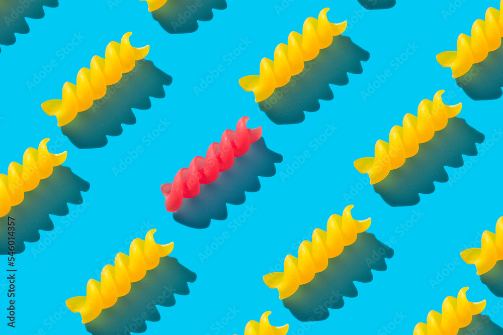 Raw fusilli pasta on blue background top view. Repeating seamless pattern.