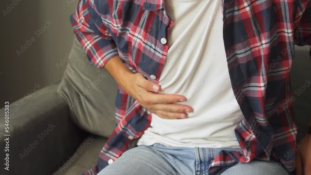 A guy's stomach hurts at home. A guy's stomach hurts at home.
