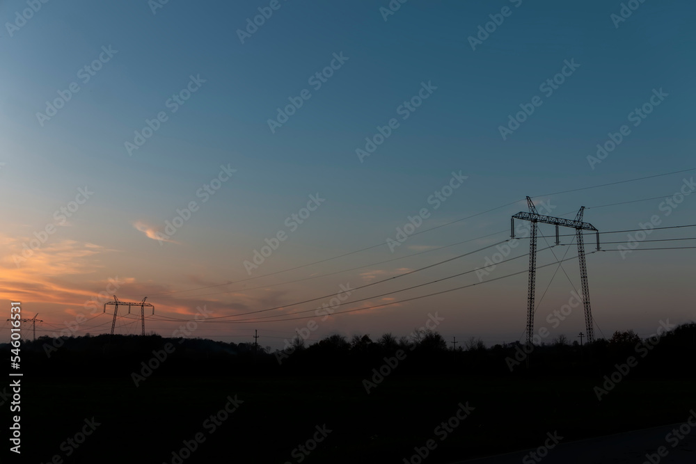 High voltage power lines at sunset.In future - scarcity of electricity. Due to high prices desperate people have no money to pay for electricity