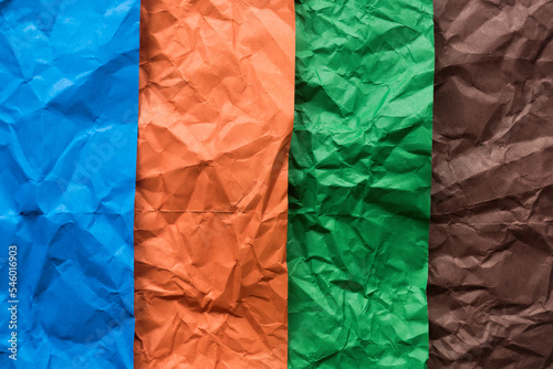 Blue, orange, green and brown crumpled paper for background.