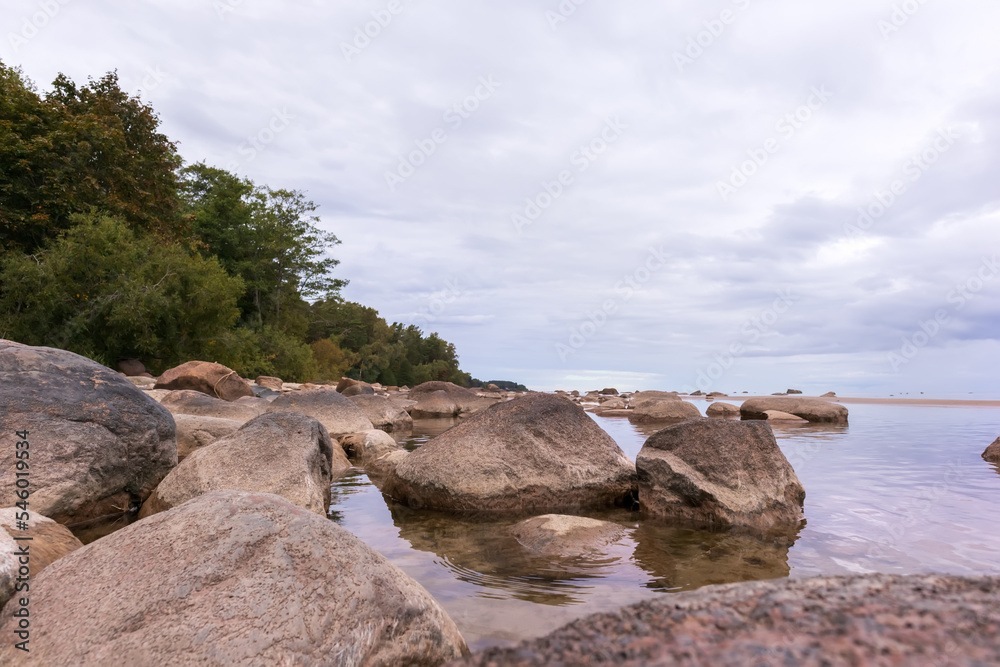 Sea view with blue sky, various rocks and green trees