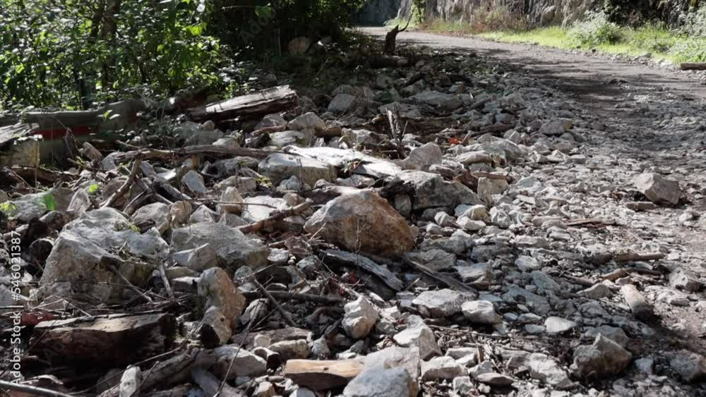 An old abandoned highway in the mountains. Rock and tree collapses, rockfalls on the road. Rocks, mountain gorge. Damaged bumpers on the side of the road. An old abandoned highway in the mountains. Rock and tree collapses, rockfalls on the road. Rocks, mountain gorge. Damaged bumpers on the side of the road.